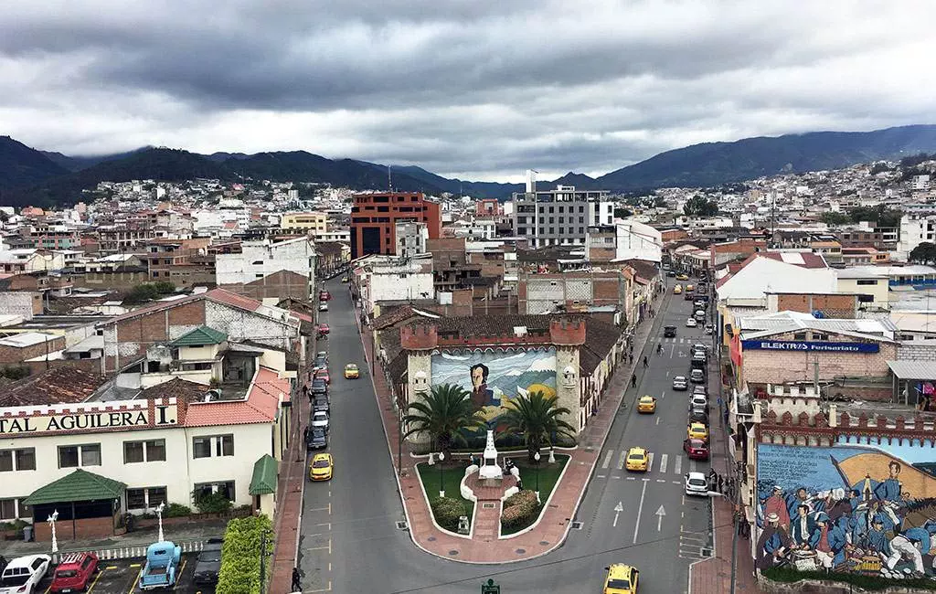 Una vista aérea de la ciudad de Loja con montañas al fondo.